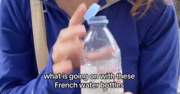 woman holding a tethered water bottle with writing over it